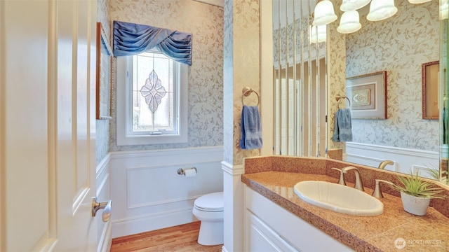 8504 146th Pl SE, Newcastle, WA 98059 - bathroom with wallpapered walls, wainscoting, vanity, toilet, and wood finished floors