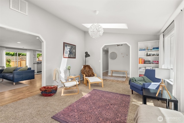 4434 Juli Ct SE, Olympia, WA 98501 - living area featuring arched walkways, a skylight, lofted ceiling, wood finished floors, and carpet floors