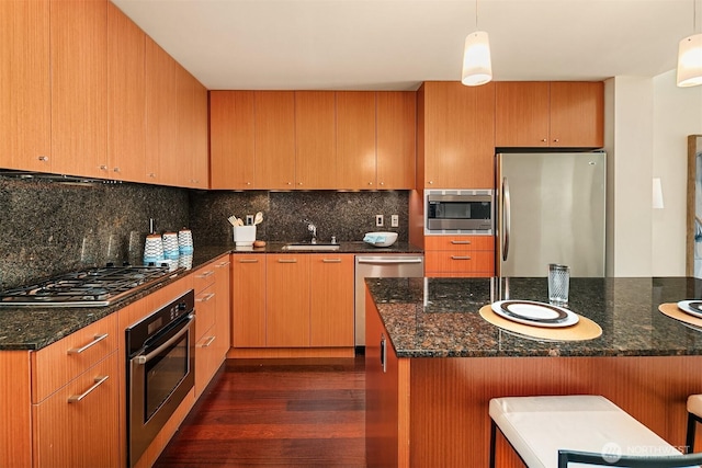 909 5th Ave Unit 303, Seattle, WA 98164 - kitchen featuring appliances with stainless steel finishes, dark wood-style flooring, tasteful backsplash, and pendant lighting