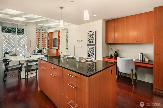909 5th Ave Unit 303, Seattle, WA 98164 - kitchen featuring dark wood-type flooring, a center island, dark stone counters, plenty of natural light, and recessed lighting