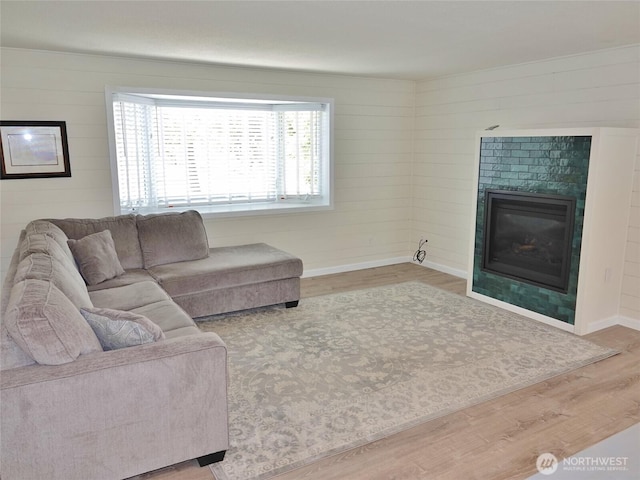 137 S Razor Clam Dr SW, Ocean Shores, WA 98569 - living area with wood finished floors, a glass covered fireplace, baseboards, and wooden walls