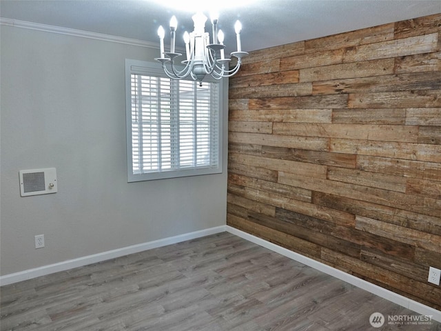 137 S Razor Clam Dr SW, Ocean Shores, WA 98569 - empty room featuring a chandelier, wooden walls, baseboards, ornamental molding, and wood finished floors