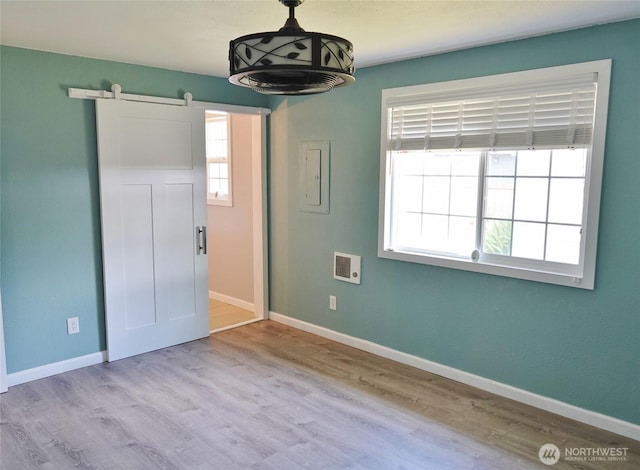 137 S Razor Clam Dr SW, Ocean Shores, WA 98569 - spare room featuring a barn door, baseboards, and wood finished floors