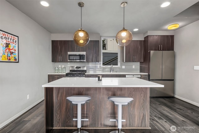 3617 1st Ave NW Unit C, Seattle, WA 98107 - kitchen featuring stainless steel appliances, a sink, baseboards, a kitchen island, and recessed lighting