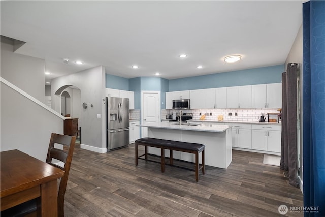 6858 Flute St SE, Lacey, WA 98513 - kitchen with stainless steel appliances, arched walkways, dark wood-type flooring, backsplash, and recessed lighting