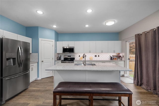 6858 Flute St SE, Lacey, WA 98513 - kitchen with appliances with stainless steel finishes, a sink, wood finished floors, backsplash, and recessed lighting