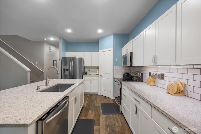 6858 Flute St SE, Lacey, WA 98513 - kitchen featuring appliances with stainless steel finishes, a sink, white cabinetry, dark wood-style flooring, and backsplash