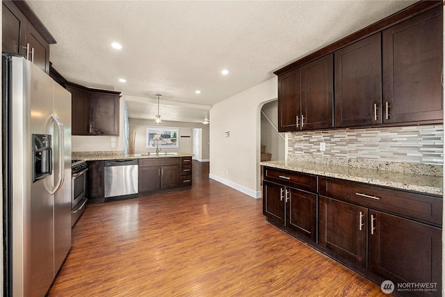 4050 E G St, Tacoma, WA 98404 - kitchen featuring appliances with stainless steel finishes, dark wood-type flooring, a peninsula, backsplash, and recessed lighting