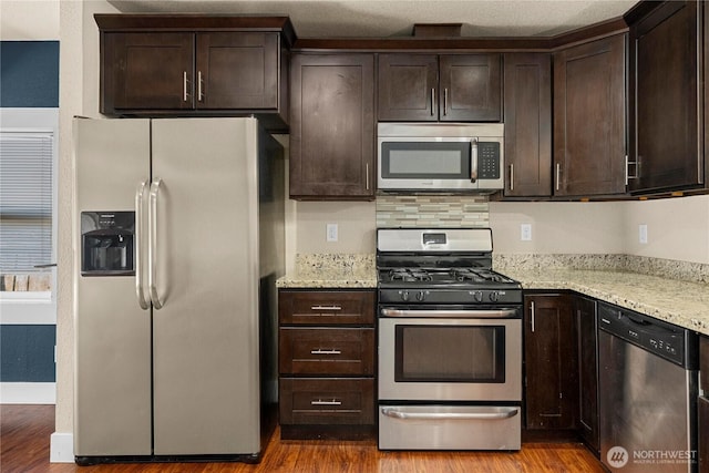 4050 E G St, Tacoma, WA 98404 - kitchen with appliances with stainless steel finishes, dark brown cabinetry, and wood finished floors