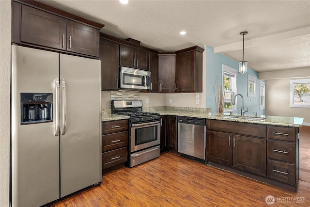 4050 E G St, Tacoma, WA 98404 - kitchen with stainless steel appliances, a peninsula, dark brown cabinets, dark wood finished floors, and recessed lighting