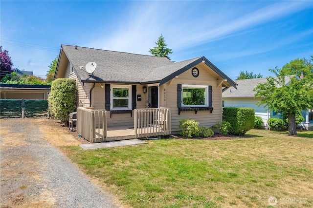 4050 E G St, Tacoma, WA 98404 - view of front of home with a front yard, a wooden deck, and roof with shingles