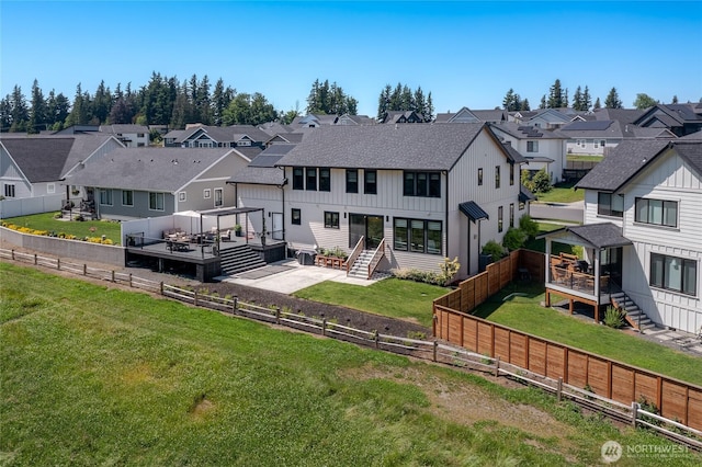 2140 Lagerwey Cir, Lynden, WA 98264 - rear view of house with a residential view, a deck, a fenced backyard, board and batten siding, and stairway