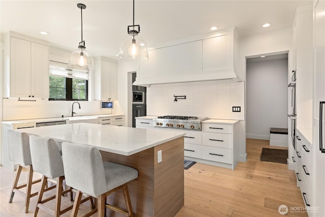 2140 Lagerwey Cir, Lynden, WA 98264 - kitchen featuring stainless steel appliances, a center island, tasteful backsplash, white cabinets, and a breakfast bar