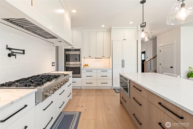 2140 Lagerwey Cir, Lynden, WA 98264 - kitchen with appliances with stainless steel finishes, custom exhaust hood, light wood-type flooring, recessed lighting, and tasteful backsplash