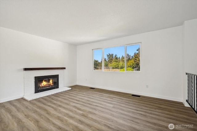 16931 20th Dr SE, Bothell, WA 98012 - unfurnished living room with wood finished floors, baseboards, and a brick fireplace