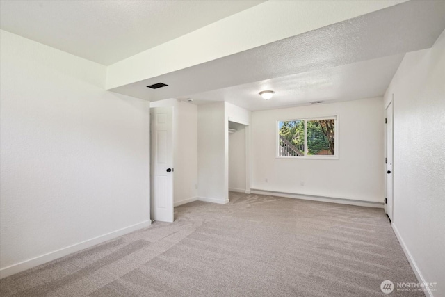 16931 20th Dr SE, Bothell, WA 98012 - unfurnished bedroom featuring a baseboard radiator, light colored carpet, baseboards, and a textured ceiling
