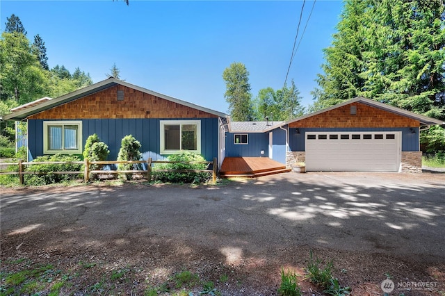 9341 Littlerock Rd SW, Olympia, WA 98512 - view of front facade featuring stone siding, an attached garage, asphalt driveway, and a wooden deck