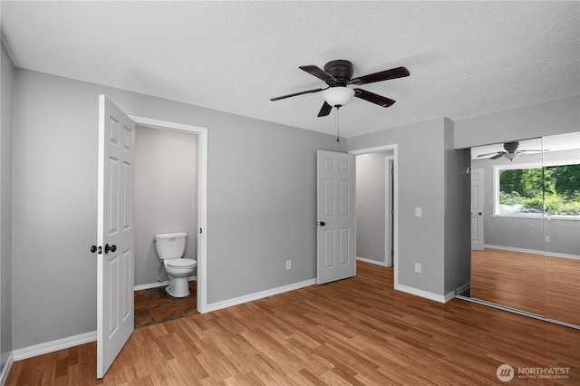 9341 Littlerock Rd SW, Olympia, WA 98512 - unfurnished bedroom featuring light wood-style floors, a textured ceiling, baseboards, and ensuite bathroom