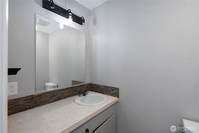 9341 Littlerock Rd SW, Olympia, WA 98512 - half bathroom with toilet, vanity, and tasteful backsplash