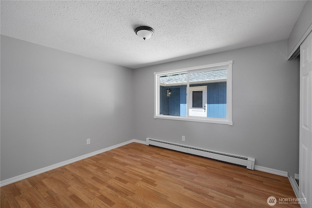9341 Littlerock Rd SW, Olympia, WA 98512 - spare room featuring a baseboard heating unit, wood finished floors, a textured ceiling, and baseboards