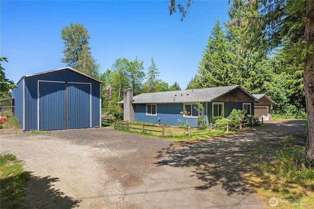 9341 Littlerock Rd SW, Olympia, WA 98512 - view of front of house with driveway, an outbuilding, a detached garage, a garage, and a chimney