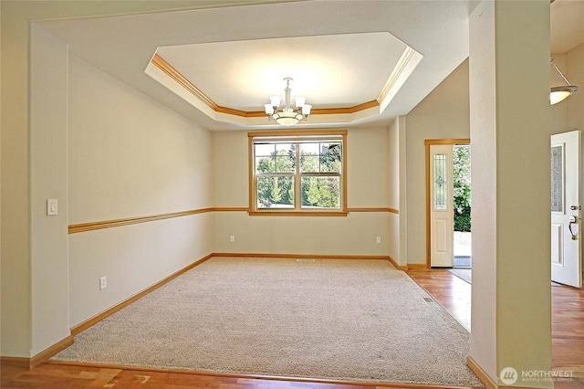 26306 2nd Ave NE, Arlington, WA 98223 - carpeted empty room with plenty of natural light, a chandelier, a raised ceiling, ornamental molding, and wood finished floors