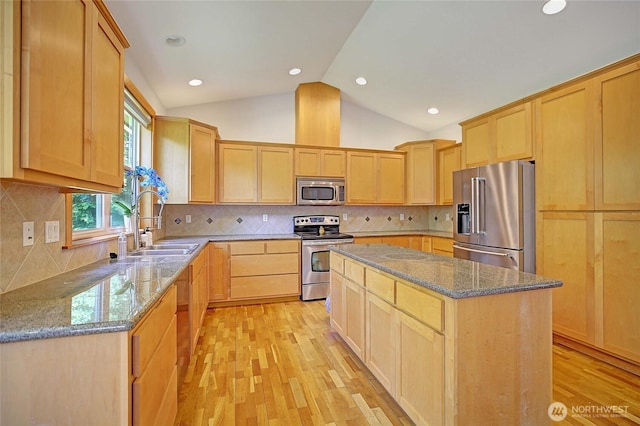 26306 2nd Ave NE, Arlington, WA 98223 - kitchen featuring appliances with stainless steel finishes, light brown cabinets, light wood-type flooring, vaulted ceiling, and stone countertops