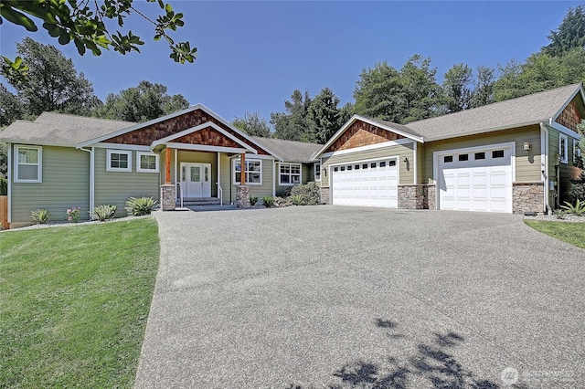 26306 2nd Ave NE, Arlington, WA 98223 - craftsman inspired home featuring stone siding, driveway, a garage, a front lawn, and a shingled roof