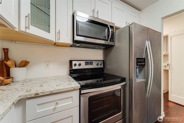 14251 73rd Ave NE Unit A101, Kirkland, WA 98034 - kitchen with appliances with stainless steel finishes, dark wood-style flooring, glass insert cabinets, white cabinets, and light stone countertops