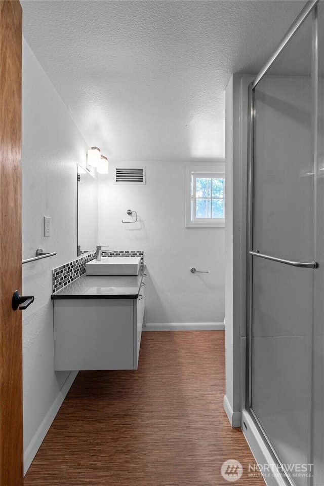 1484 SW Snively Ave, Chehalis, WA 98532 - full bathroom featuring vanity, wood finished floors, baseboards, a shower stall, and a textured ceiling