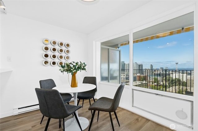 505 Belmont Ave E Unit 704, Seattle, WA 98102 - dining area featuring a baseboard heating unit, wood finished floors, and a city view