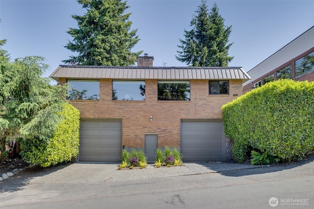 8814 Earl Ave NW, Seattle, WA 98117 - view of front facade with a chimney, brick siding, and a metal roof