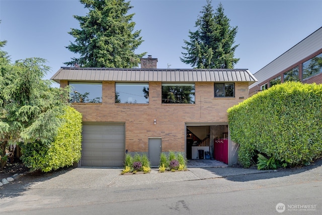 8814 Earl Ave NW, Seattle, WA 98117 - view of front of home with a chimney, a metal roof, brick siding, and a standing seam roof