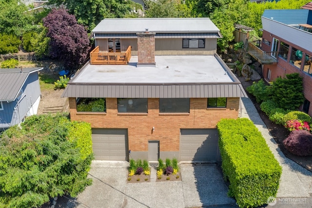 8814 Earl Ave NW, Seattle, WA 98117 - view of front of property featuring concrete driveway, brick siding, an attached garage, and a balcony