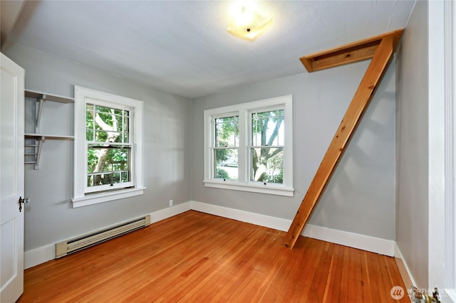 715 Grant St, Port Townsend, WA 98368 - unfurnished bedroom with baseboard heating, wood finished floors, and multiple windows