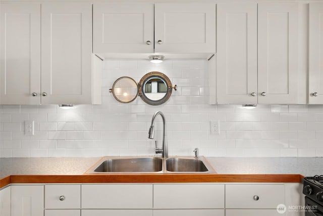 360 W Ewing St Unit D3, Seattle, WA 98119 - kitchen featuring a sink, white cabinets, and decorative backsplash