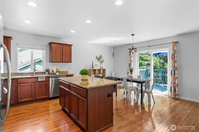 8305 172nd Pl NE, Arlington, WA 98223 - kitchen featuring appliances with stainless steel finishes, light wood-type flooring, a kitchen island, light stone countertops, and recessed lighting