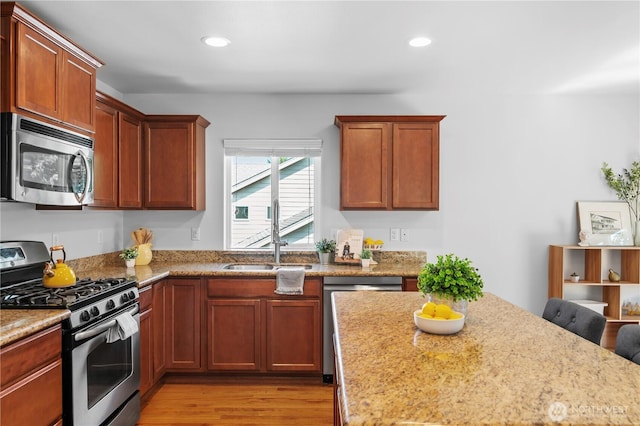 8305 172nd Pl NE, Arlington, WA 98223 - kitchen featuring stainless steel appliances, light wood finished floors, light stone countertops, recessed lighting, and a sink