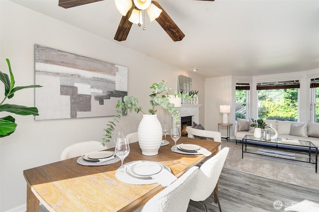 17913 158th Pl SE, Renton, WA 98058 - dining space with a brick fireplace, a ceiling fan, wood finished floors, and baseboards