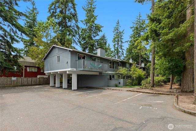 7520 208th St SW Unit A104, Edmonds, WA 98026 - view of front of property featuring uncovered parking, a chimney, and a balcony