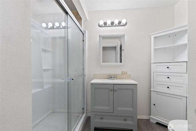 7520 208th St SW Unit A104, Edmonds, WA 98026 - bathroom featuring a stall shower, vanity, and wood finished floors