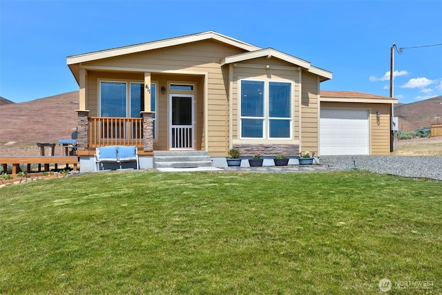 411 Terrett Way, Yakima, WA 98901 - view of front of home with a front yard, a garage, stone siding, driveway, and an outdoor living space