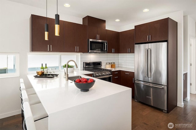 2012 14th Ave S, Seattle, WA 98144 - kitchen with appliances with stainless steel finishes, a sink, a peninsula, light countertops, and dark brown cabinets