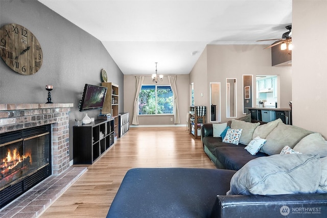 1226 Juniper Dr SE, Olympia, WA 98513 - living room featuring wood finished floors, vaulted ceiling, a brick fireplace, a chandelier, and a ceiling fan