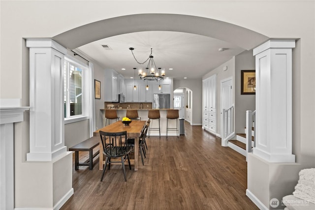 1711 Eagles Nest Pl SE, North Bend, WA 98045 - dining area featuring arched walkways, dark wood finished floors, and a chandelier