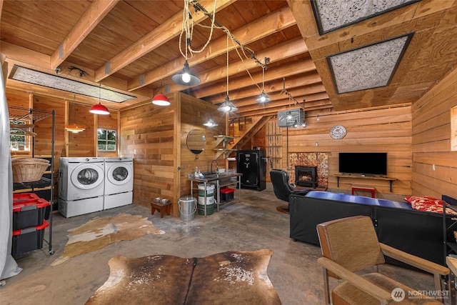 329 Columbia St, Sumas, WA 98295 - living area with separate washer and dryer, wood walls, wood ceiling with exposed beams, unfinished concrete floors, and a stone fireplace