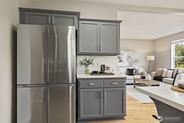 26216 SE 228th Ave SE Unit 26216, Maple Valley, WA 98038 - kitchen featuring freestanding refrigerator, gray cabinets, light countertops, light wood-style flooring, and tasteful backsplash