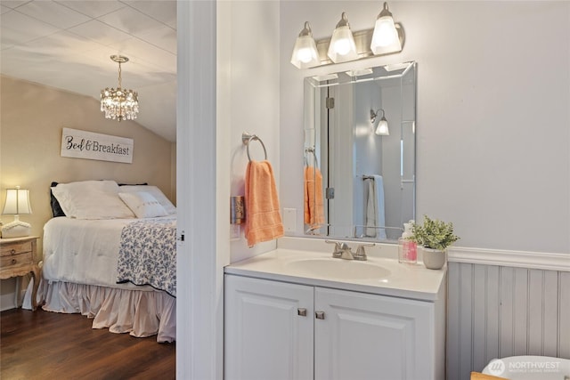 1007 N Ferdinand St, Tacoma, WA 98406 - ensuite bathroom featuring vanity, a chandelier, wood finished floors, and vaulted ceiling