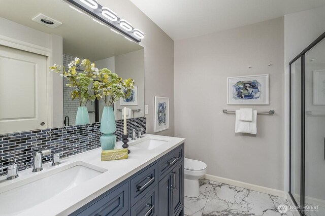 124 Bellevue Ave E Unit 305, Seattle, WA 98102 - bathroom with marble look tiles, decorative backsplash, double vanity, a shower stall, and toilet