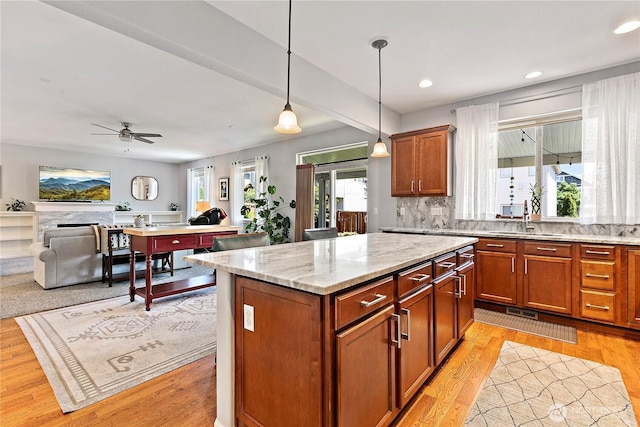 8521 15th Ave SE, Olympia, WA 98513 - kitchen with pendant lighting, light stone counters, recessed lighting, and brown cabinetry
